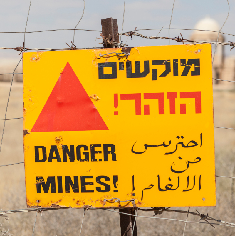 Landmines danger sign near a church in the israeli desert